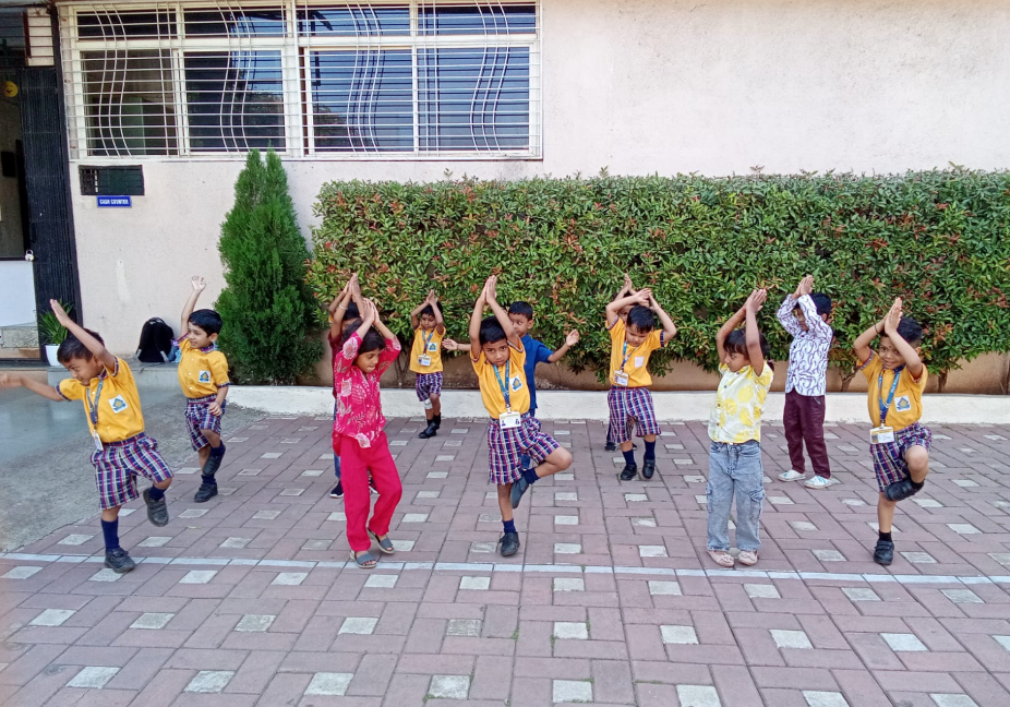 Pre-primary students practicing Tree Pose yoga outdoors