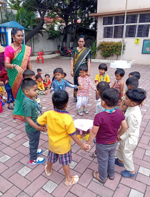 Children holding hands in a circle in the courtyard during a school activity